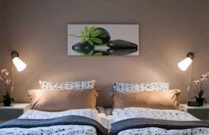 a bedroom with two beds and a picture on the wall at Ferienwohnung CityFlair _ 32290 in Rostock
