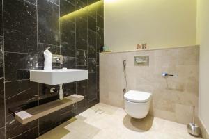 a bathroom with a white toilet and a sink at Bespoke Holiday Homes - Palm Jumeirah- 2 Bedroom Sea View with Pool & Beach Access, Th8 in Dubai