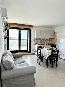 ein Wohnzimmer mit einem Sofa und einem Tisch mit Stühlen in der Unterkunft Attico Viola in Leverano