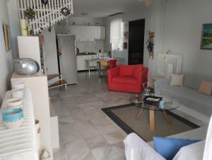uma sala de estar com um sofá e uma cadeira vermelha em 7 Seas House em Kalivia Poligirou