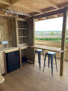 a bar on a deck with two stools at Dukeries Retreat in Retford