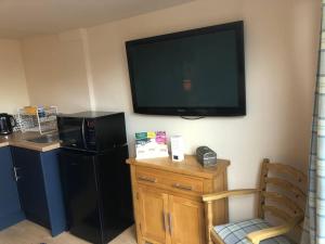 a room with a black refrigerator and a flat screen tv at Adorable 1 bedroom apartment in Ironbridge in Telford