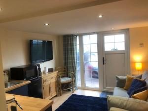 cocina y sala de estar con sofá y TV en Adorable 1 bedroom apartment in Ironbridge en Telford