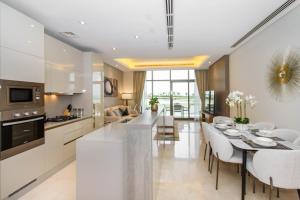 a kitchen and dining room with a table and chairs at Bespoke Holiday Homes - Palm Jumeirah- 2 Bedroom Sea View with Pool & Beach Access, Th8 in Dubai