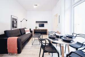 - un salon avec un canapé, une table et des chaises dans l'établissement Apartamenty Pamiątkowa 11, 2 rooms, self check in 24h, à Poznań