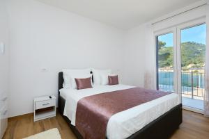 a bedroom with a large bed and a large window at Green Lantern apartments Okuklje in Okuklje
