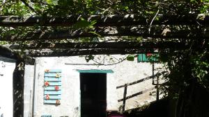a small white building with a door and a tree at Cascina Marasca Appartamento Viola in Martina Olba