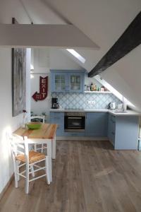a kitchen with blue cabinets and a wooden table and chairs at Ferienwohnung Luna in Trier +17 photos