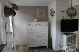 a bedroom with a white dresser with a television on it at Ferienwohnung Luna in Trier