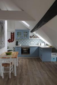 a kitchen with blue cabinets and a wooden table and a tableablish at Ferienwohnung Luna in Trier