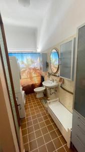 een badkamer met een wastafel, een toilet en een spiegel bij da Lilia in Salute&Bellezza in Monfalcone