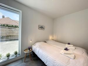 a bedroom with a bed and a large window at Villa SeaShell - Luxurious renovated gas station in Koksijde