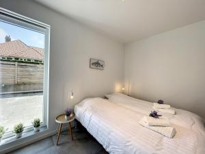 una camera da letto con un letto e una grande finestra di Villa SeaShell - Luxurious renovated gas station a Koksijde