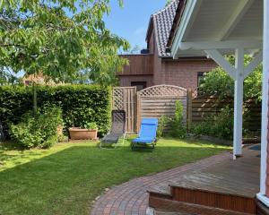 un patio con 2 sillas en un patio en Moderne Ferienwohnung mit Kamin u Garten im EG 100qm Nähe Weser und Golfplatz, en Achim