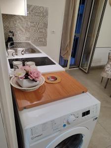 une cuisine avec un lave-linge et une planche de coupe en bois dans l'établissement Le Casette di Adele, à Palagiano