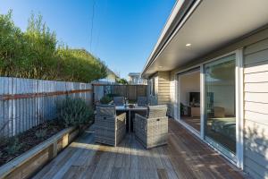 a patio with a table and chairs on a deck at Cosy and Central in Taupo