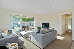 a living room with two couches and a tv at Cosy and Central in Taupo