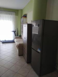 a kitchen with a refrigerator and a couch in a room at Άνετο studio σε πολυκατοικία στην Άνω Γλυφάδα in Athens