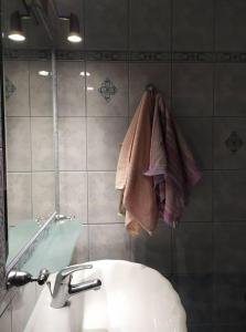 y baño con lavabo, espejo y toallas. en Άνετο studio σε πολυκατοικία στην Άνω Γλυφάδα en Athens