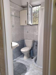 a small bathroom with a toilet and a sink at Άνετο studio σε πολυκατοικία στην Άνω Γλυφάδα in Athens