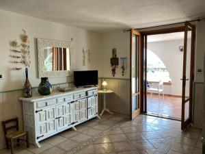 - un salon avec une commode blanche et un miroir dans l'établissement Appartamento in villa panoramica Maladroxia, à Maladroscia