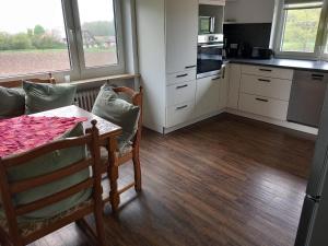a kitchen with a table and chairs and a kitchen with a stove at Ferienwohnung am Waldrand in Bechhofen
