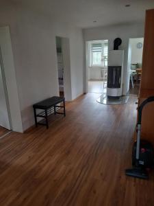 een lege woonkamer met een houten vloer en een tafel bij Ferienwohnung am Waldrand in Bechhofen