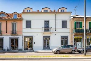 a white building with cars parked in front of it at KHL APARTMENTS - SanSiro, Milano in Milan