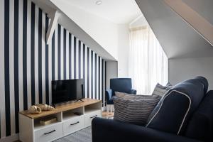 een woonkamer met een tv en twee blauwe stoelen bij Casa Ribeiro in Nazaré