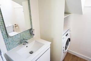 een badkamer met wastafel en wasmachine bij Casa Ribeiro in Nazaré +55 foto's