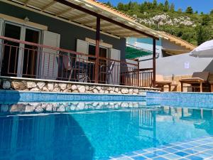 a swimming pool in front of a house at Dimarion Villas in Agios Nikitas