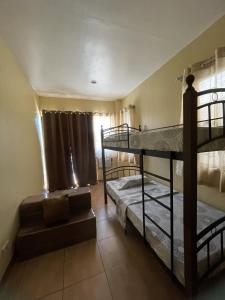 a room with two bunk beds and a couch at Astra Bella Apartment - Unit 2 in Dumaguete
