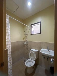 a bathroom with a toilet and a sink at Astra Bella Apartment - Unit 2 in Dumaguete