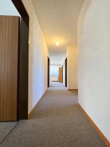 un couloir vide avec une porte menant à une chambre dans l'établissement The Nadelgrat, à Saint-Nicolas