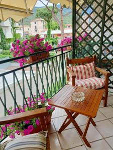 Appartamento Teresina في مارشانا مارينا: بلكونه مع طاوله ومقعد ورد