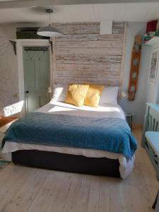 um quarto com uma cama grande e uma parede de madeira em The Artist's Retreat em Calstock