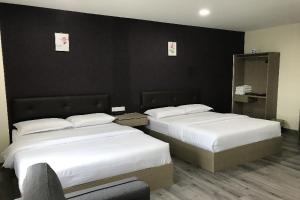 2 łóżka w pokoju hotelowym z czarnymi ścianami w obiekcie Z Stay Inn Hotel 