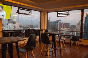 um restaurante com mesas e cadeiras e janelas grandes em Kije Place Hotel em Nairobi