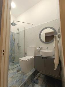 y baño con aseo, lavabo y espejo. en Hotel ROUTE 62, en Zaqatala