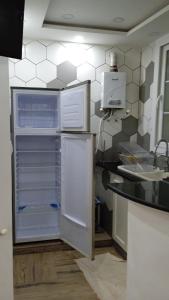 a kitchen with an open refrigerator and a sink at la perle de bougie in Bejaïa