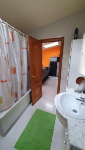 a bathroom with a sink and a shower curtain at Precioso ático en Playa América a 200 metros de la playa in Nigrán