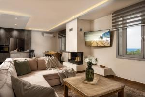 a living room with a couch and a tv at Nefeli Luxury Residence in Marathias
