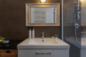 uma casa de banho com um lavatório branco e um espelho. em A Casa di Stefania by Wonderful Italy em Turim