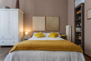 um quarto com uma cama grande e 2 almofadas amarelas em A Casa di Stefania by Wonderful Italy em Turim