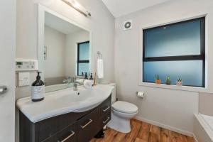 a bathroom with a sink and a toilet and a window at If I can dream in Taupo +22 photos