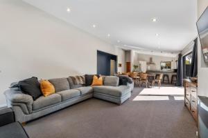 a living room with a couch and a dining room at If I can dream in Taupo