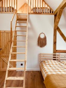 Pokój z łóżkiem piętrowym i drewnianymi schodami w obiekcie INGLOTÓWKA w mieście Wołów