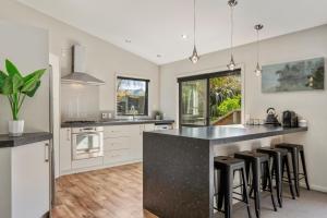 a kitchen with a black counter and stools at If I can dream in Taupo