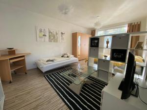 - un salon avec un lit et une table en verre dans l'établissement Apartment city centrum, à Nitra