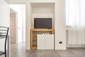 a living room with a television on a cabinet at KHL APARTMENTS - SanSiro, Milano in Milan +15 photos